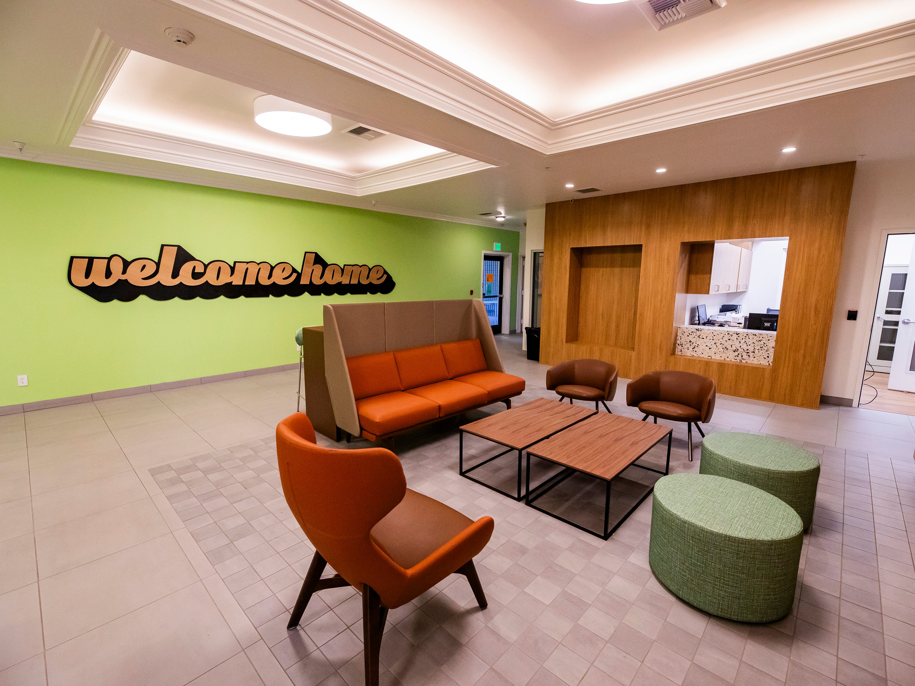 A green room with an orange couch and chairs A green room with an orange couch and chairs