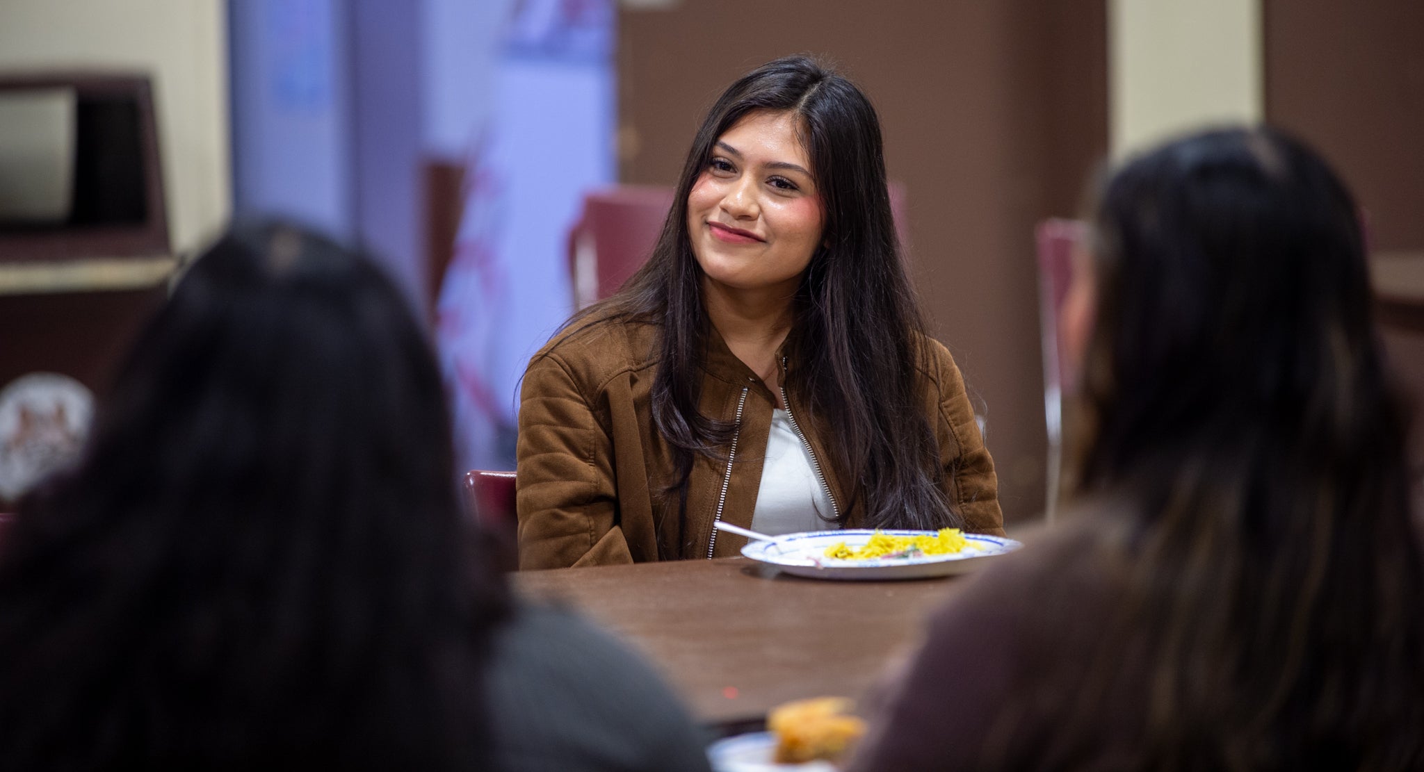 Woman smiles at people around a table. 