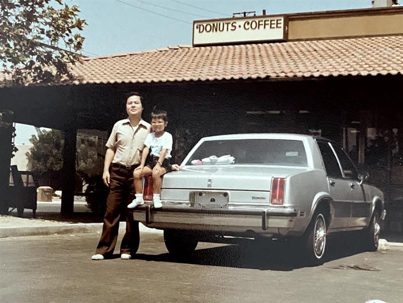 Jim (right) with his father standing in front of their donut shop. Jim (right) with his father standing in front of their donut shop.