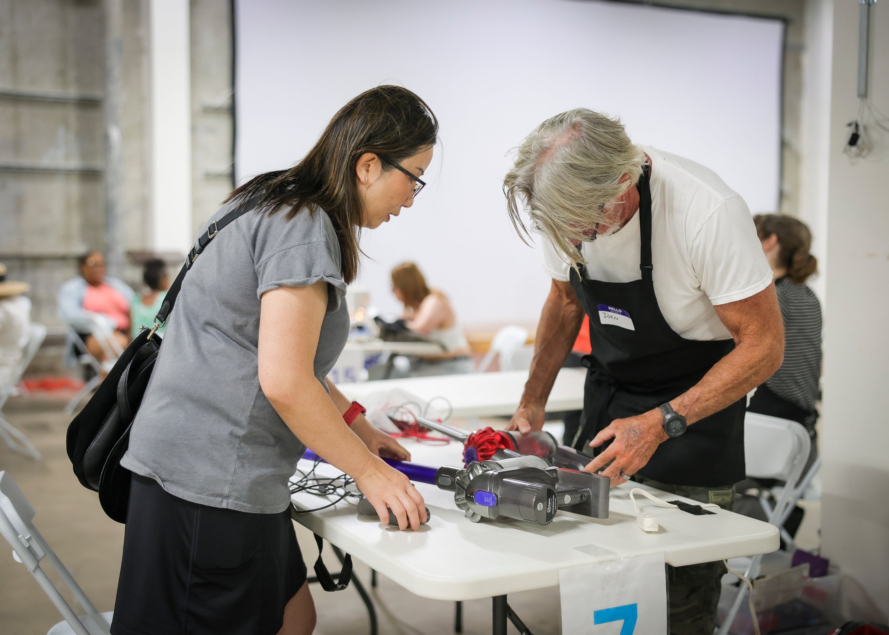 Two people fixing a vacuum Two people fixing a vacuum
