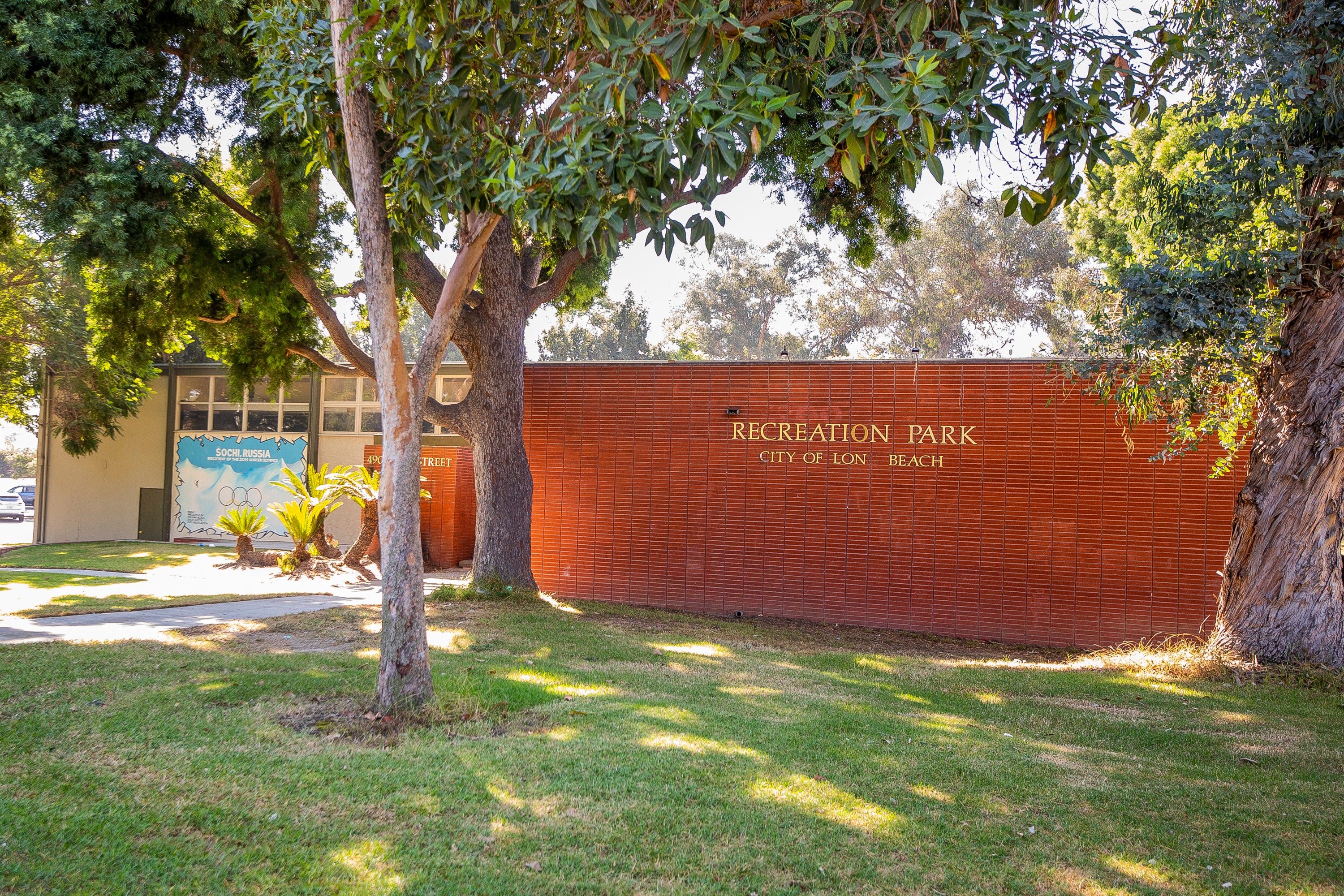 A brick building shaded by trees A brick building shaded by trees