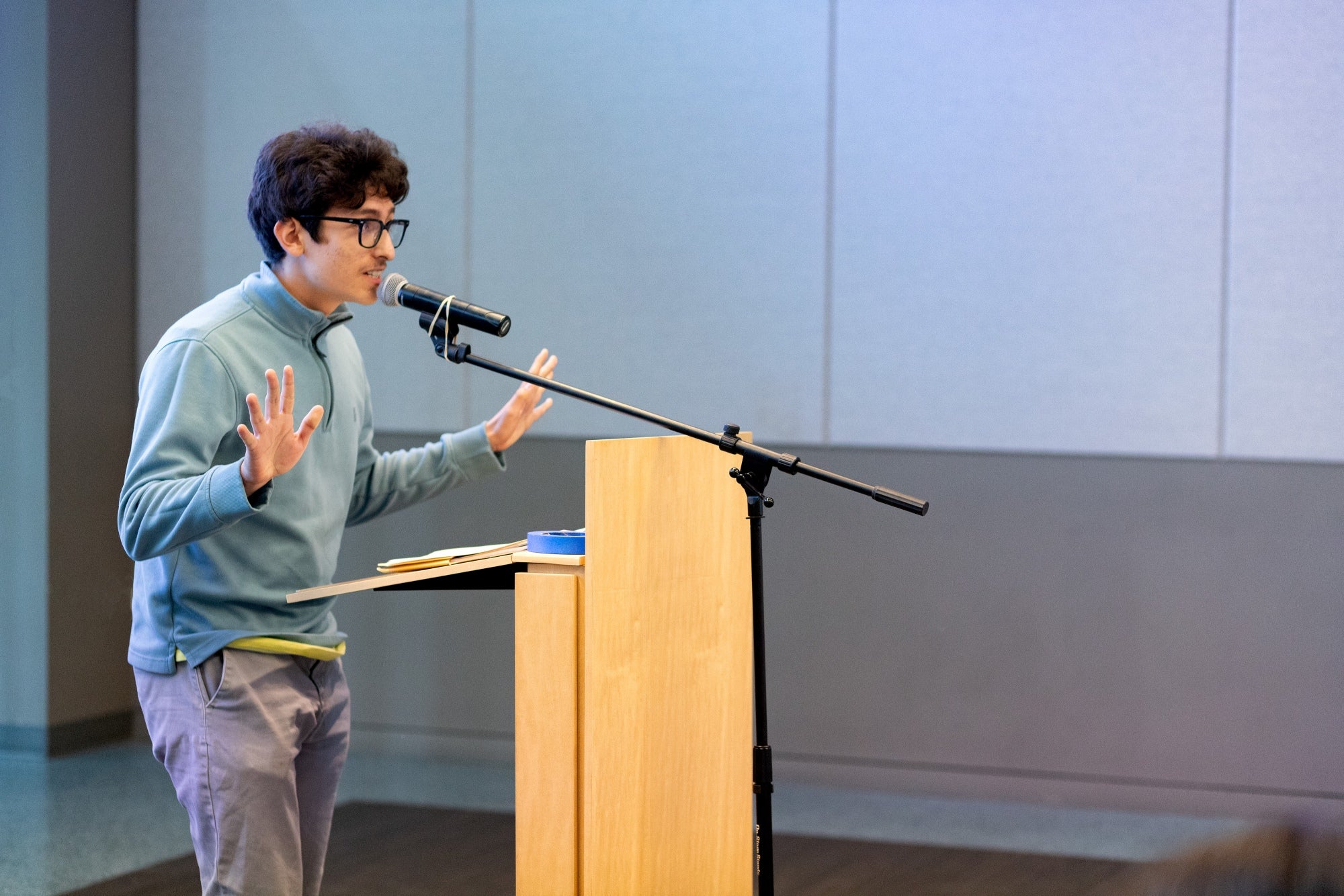 A young man speaks at a podium A young man speaks at a podium
