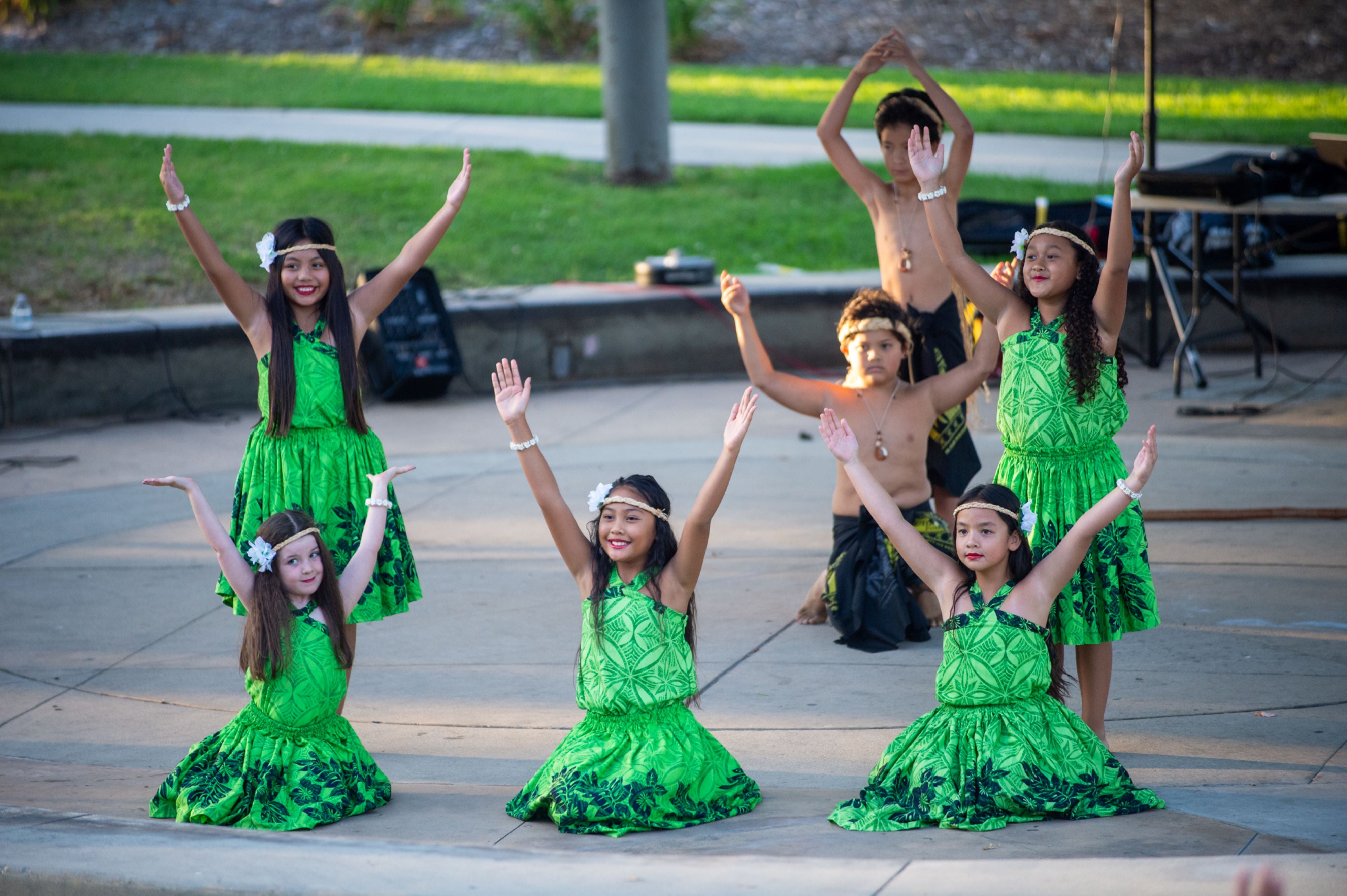 Children in green costumes performing a dance routine. Children in green costumes performing a dance routine.