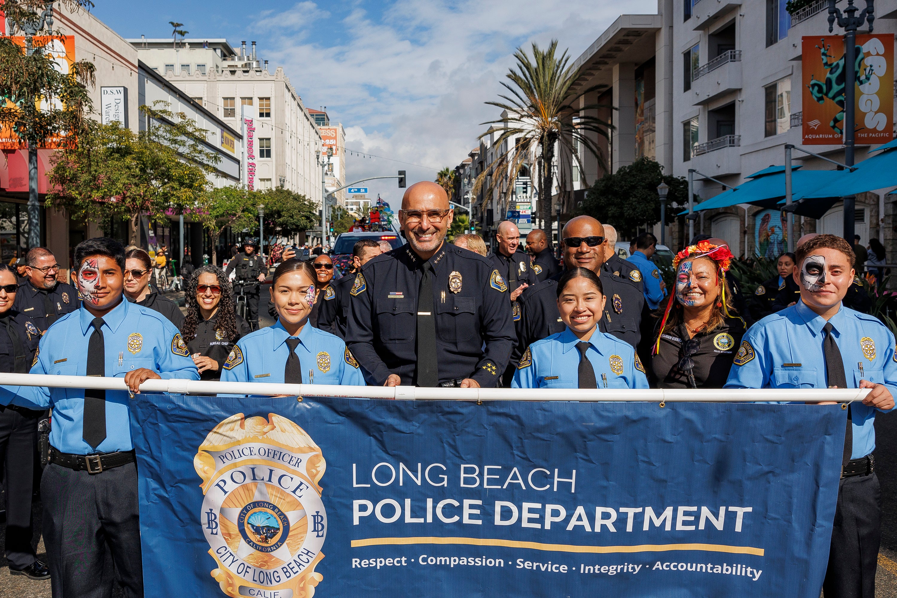 Chief of Police Wally Hebeish holding up banner alongside youth volunteers. Chief of Police Wally Hebeish holding up banner alongside youth volunteers.