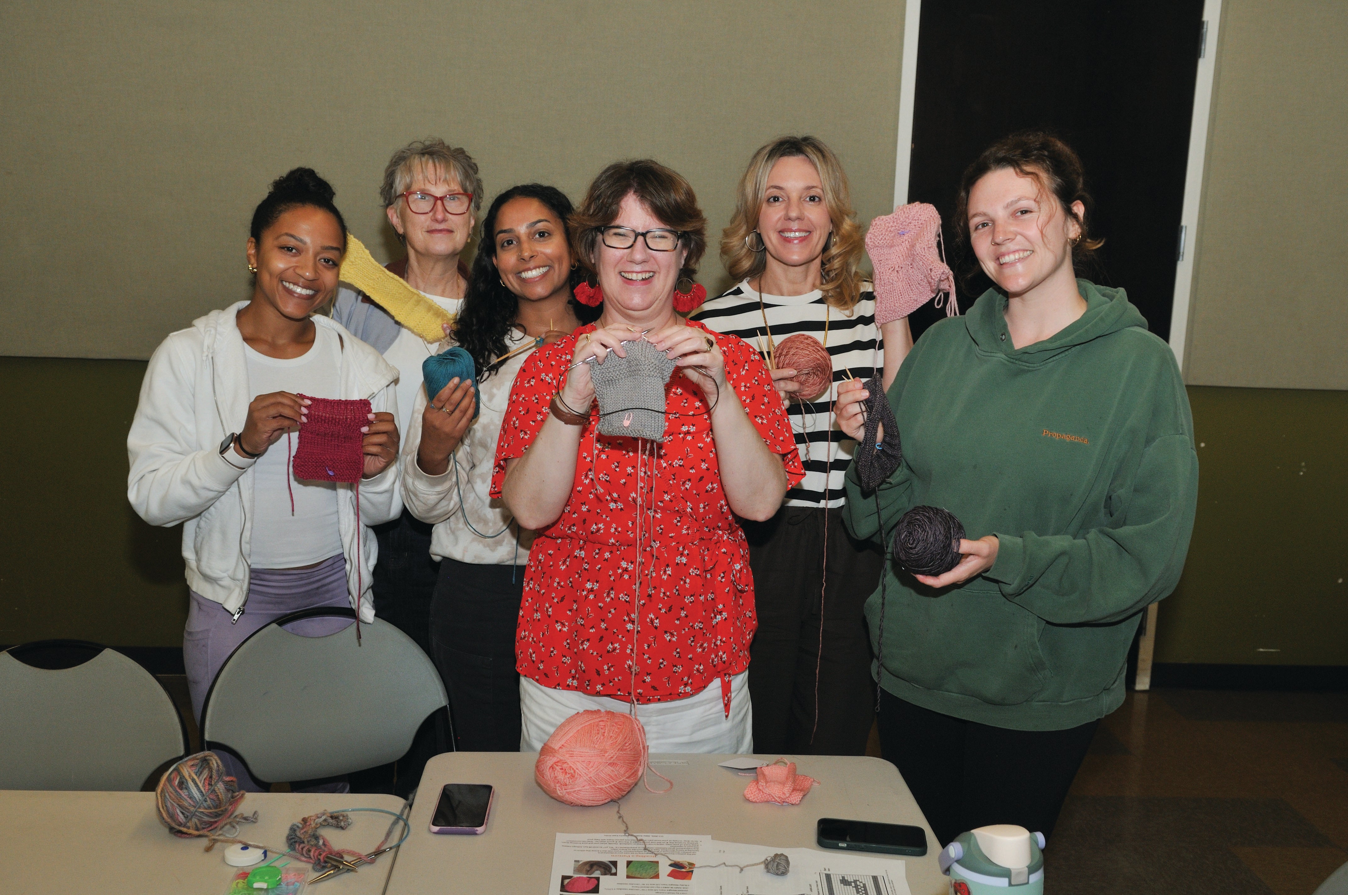 Group of people showing their knitting projects. Group of people showing their knitting projects.