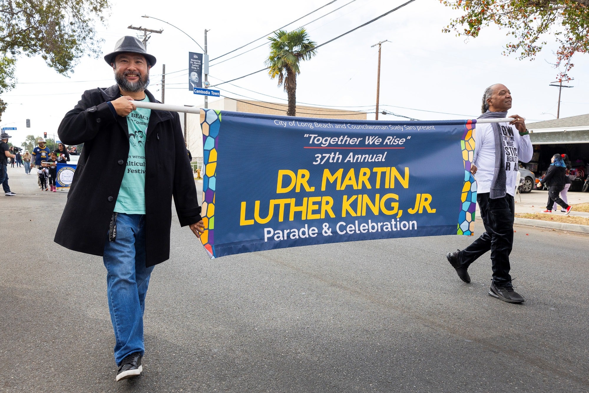 Two men hold up a banner during a parade Two men hold up a banner during a parade