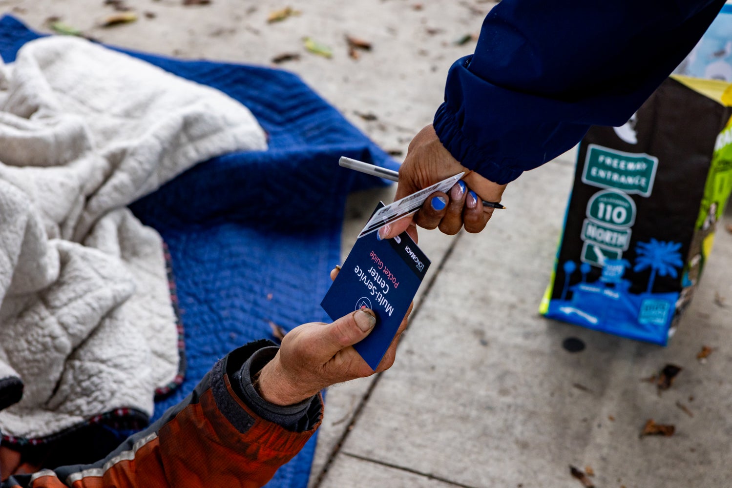 Homeless count volunteer passing out a Multi Service Center pamphlet.