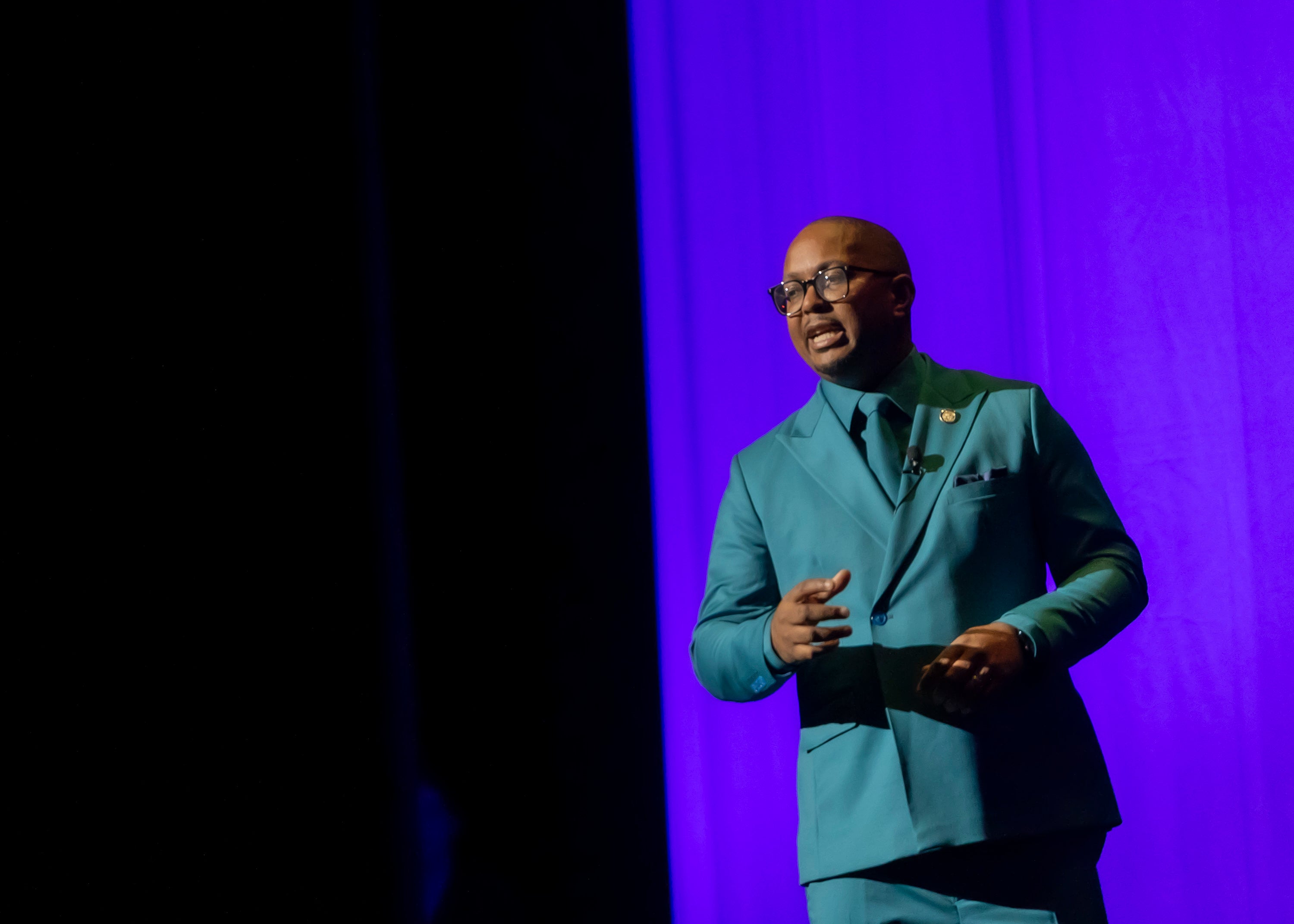 Man in a green suit on stage Man in a green suit on stage