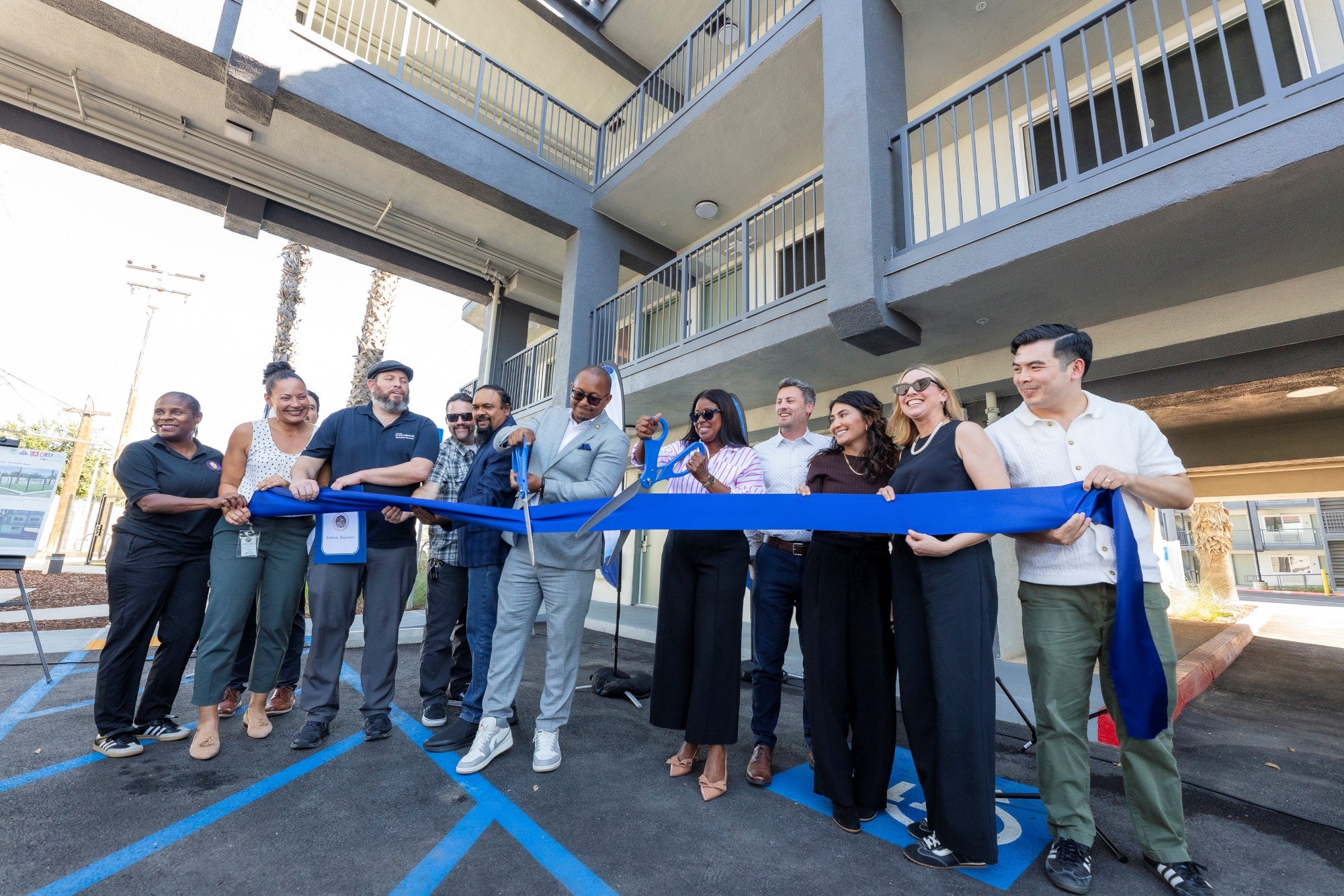 Group of people cutting a ribbon at ceremony 