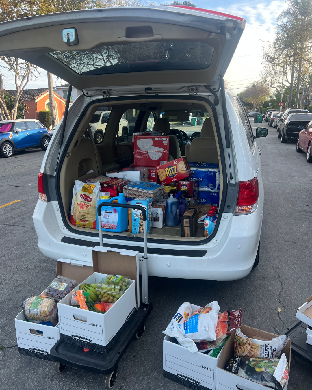Trunk of a van open and full of groceries 