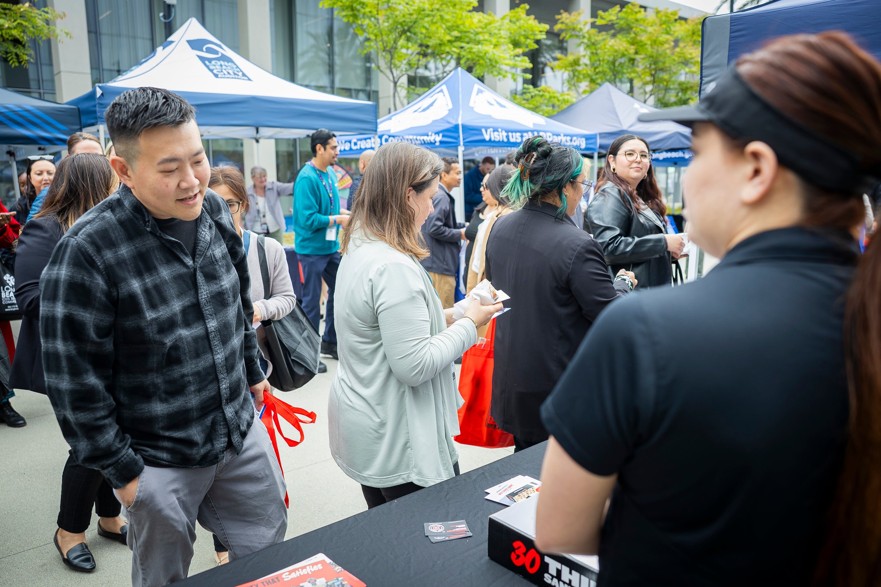 Man speaks to woman at an event booth. 