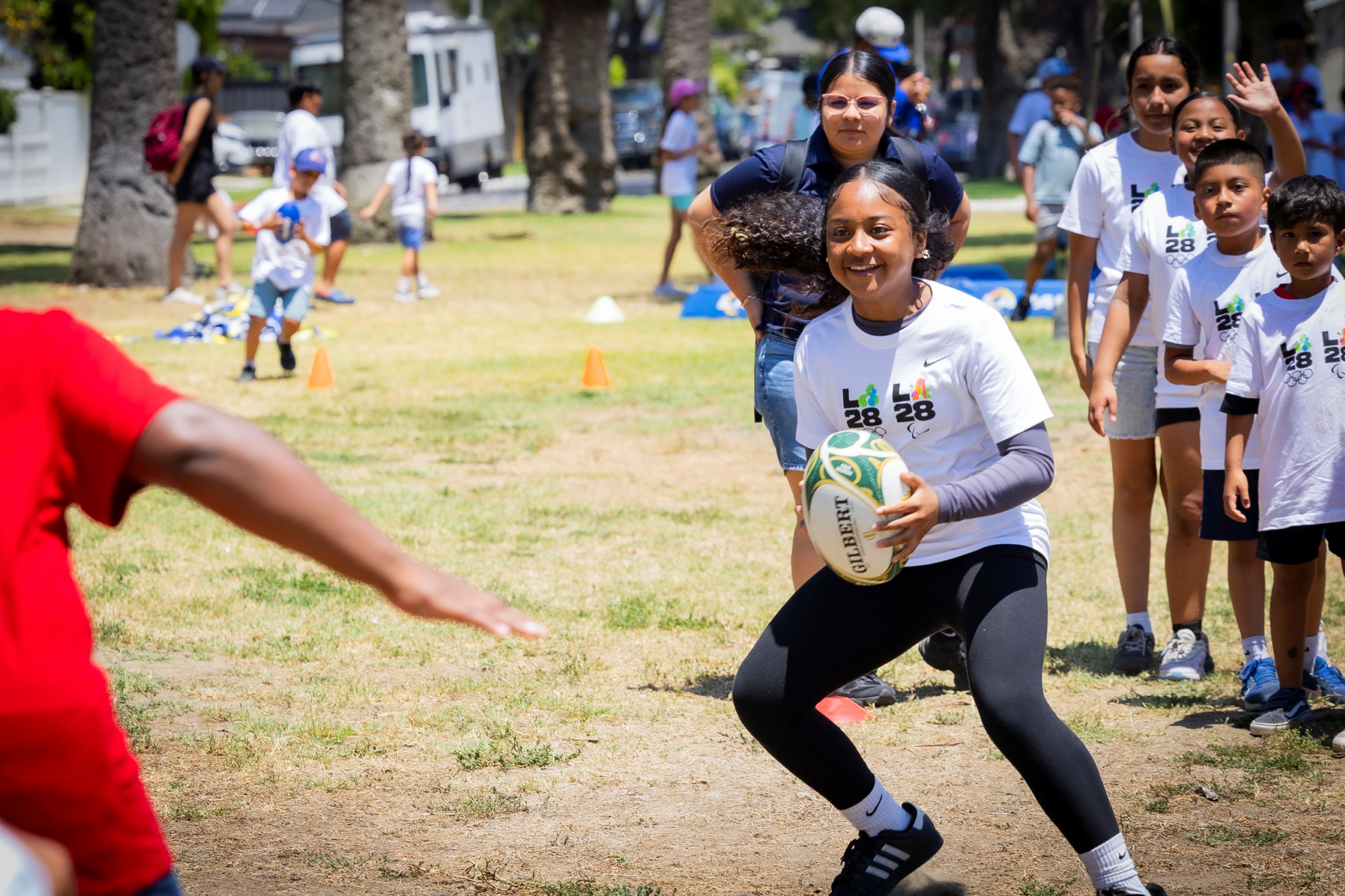 A girl holding a rugby ball in a field A girl holding a rugby ball in a field