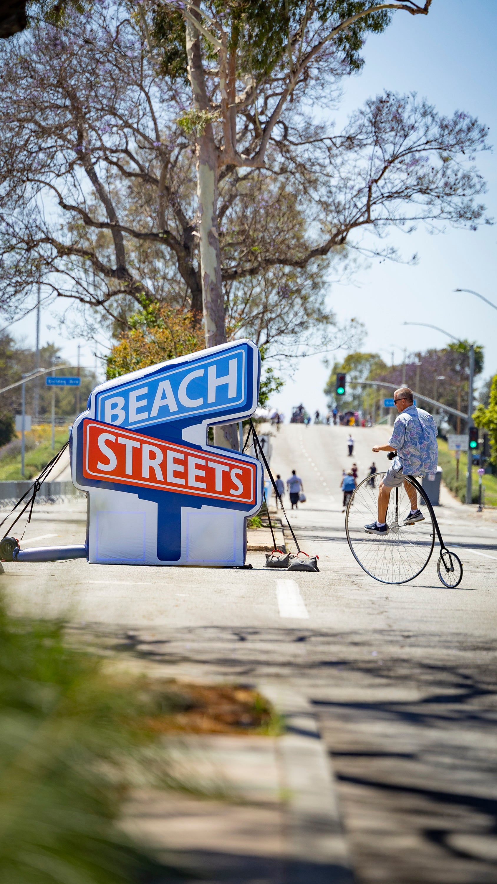 Beach Street Sign and a man riding a vintage bicycle. Beach Street Sign and a man riding a vintage bicycle.