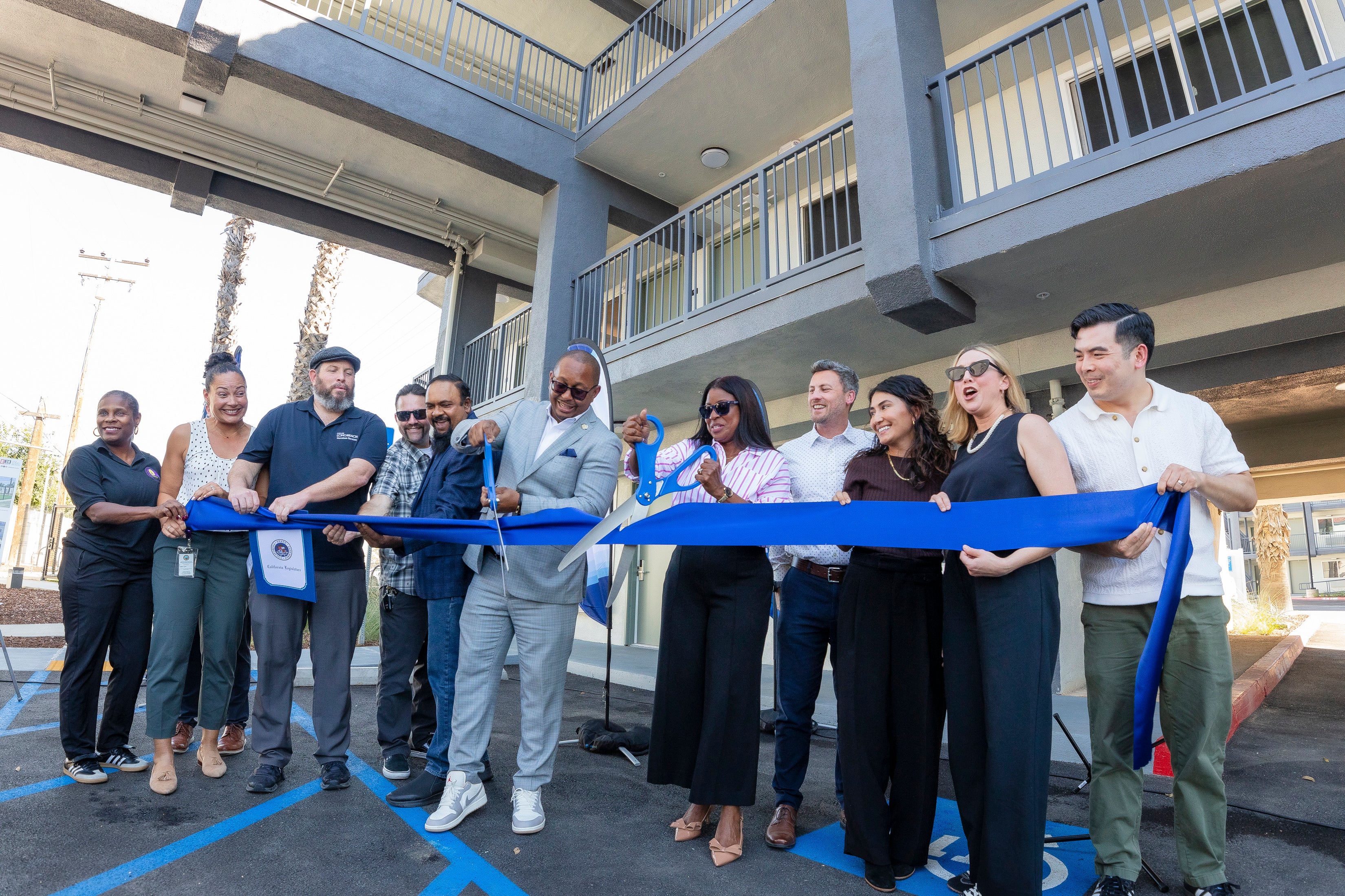 A group of people cutting a ribbon A group of people cutting a ribbon