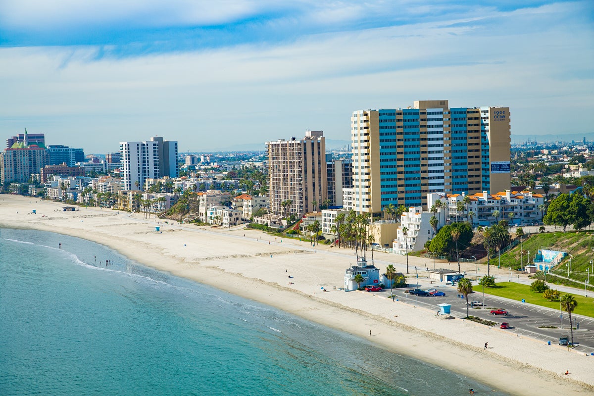Aerial shot of Long Beach's coast with buildings in background. Aerial shot of Long Beach's coast with buildings in background.