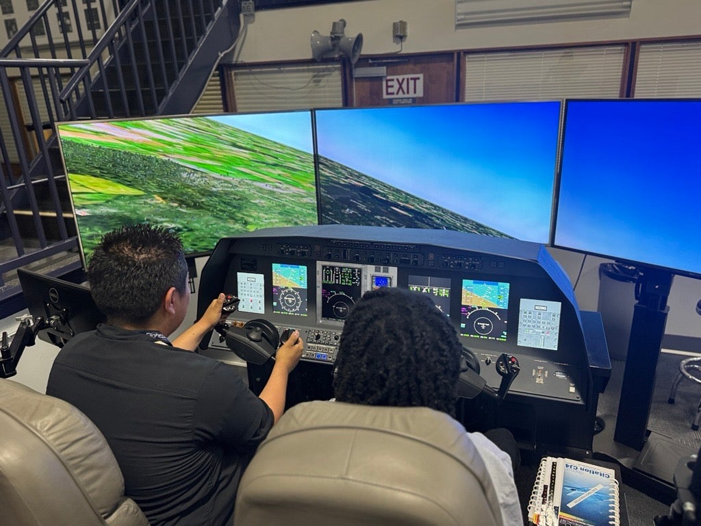 Students undertaking simulated airplane training. Students undertaking simulated airplane training.