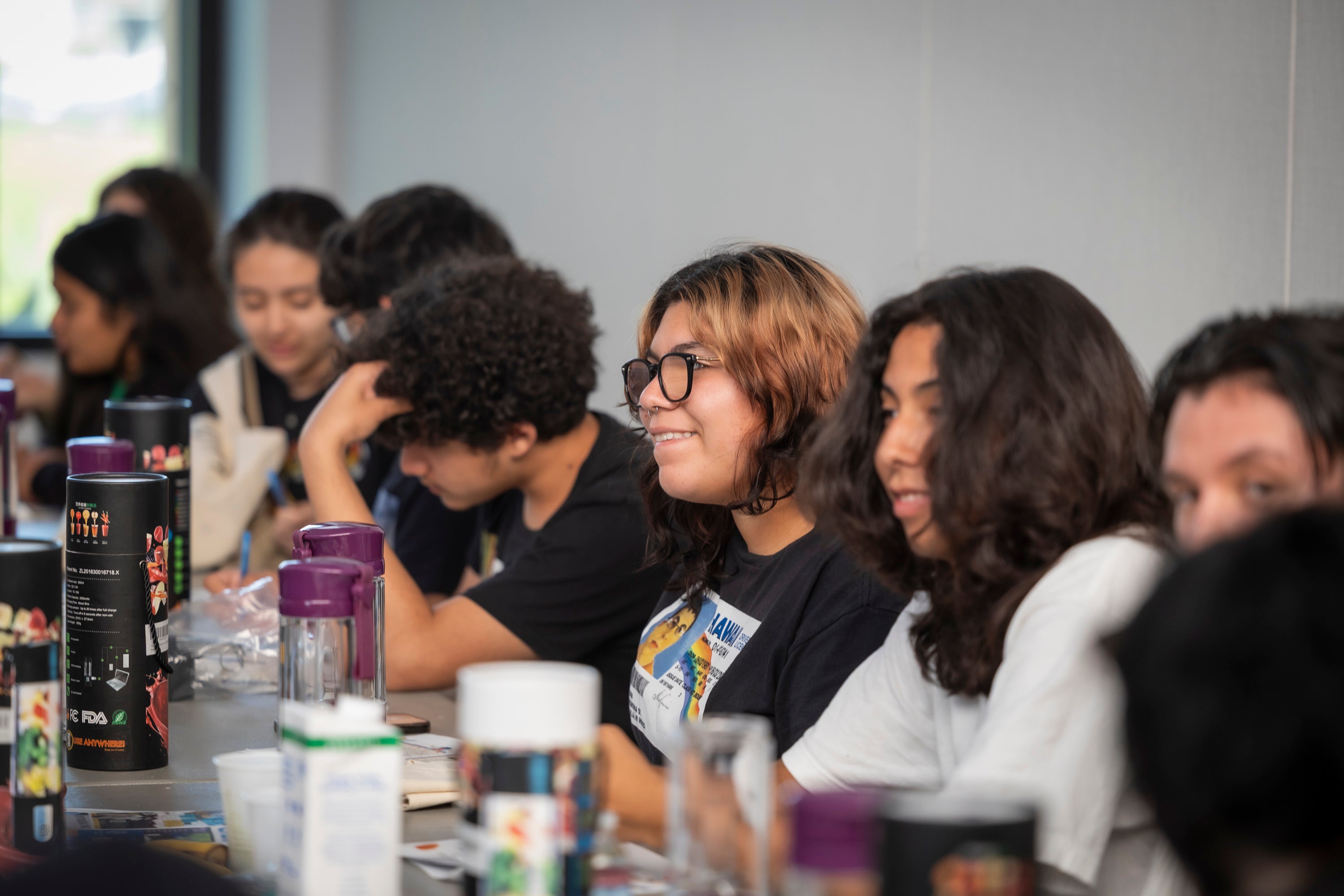 Several teenagers sitting at a table Several teenagers sitting at a table