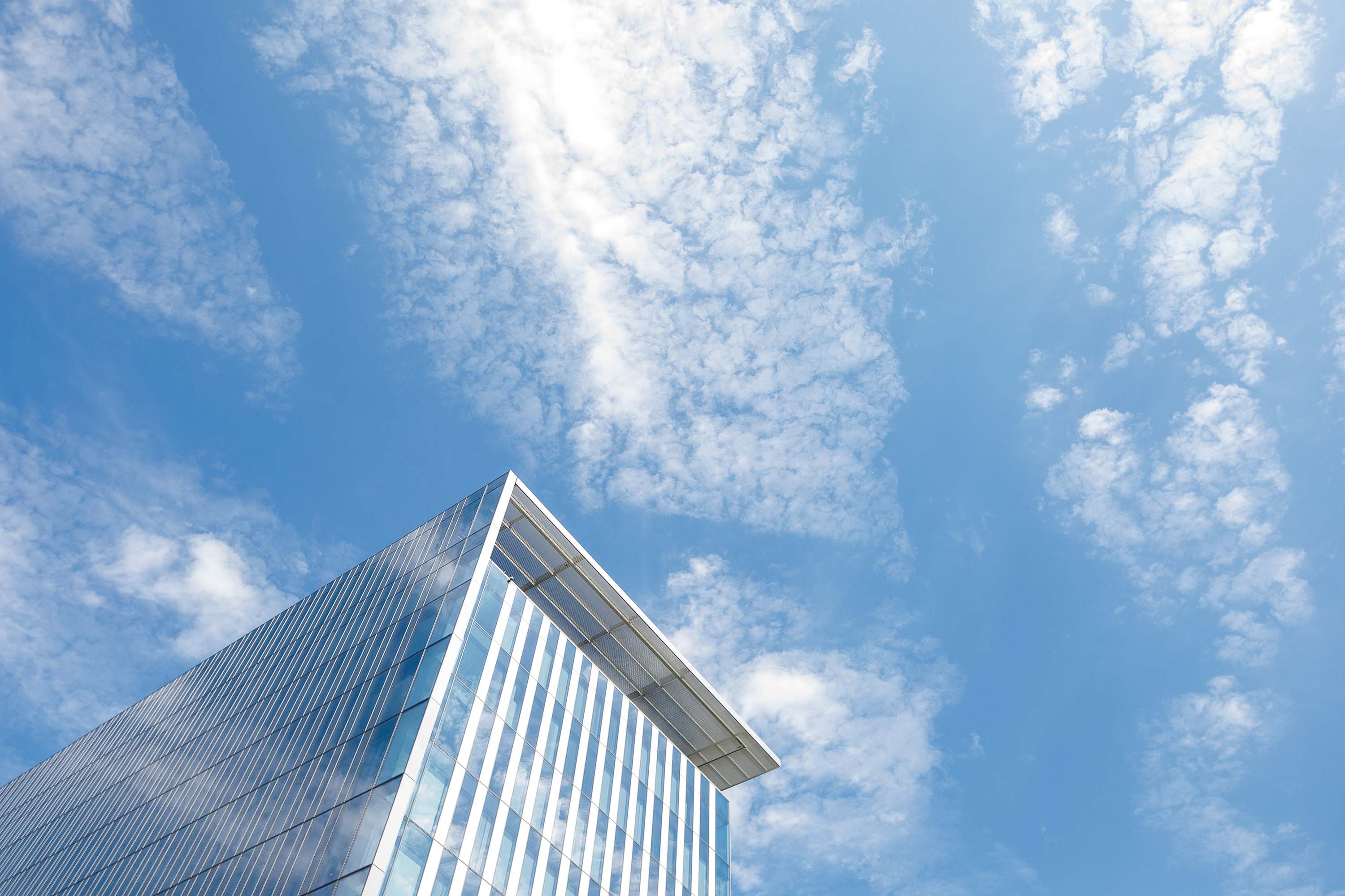 A mirrored building and a blue sky 