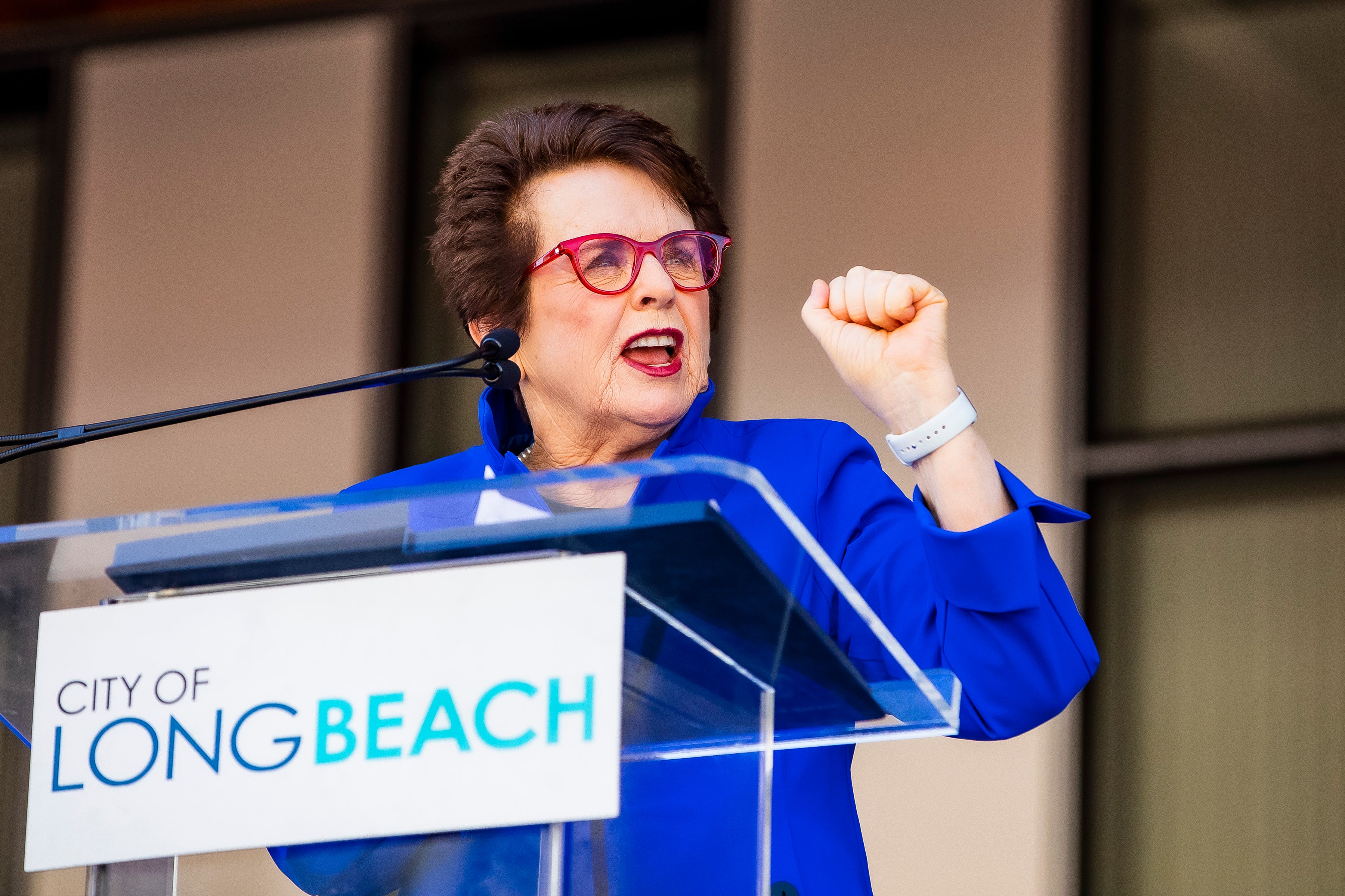Billie Jean King standing in front of a podium