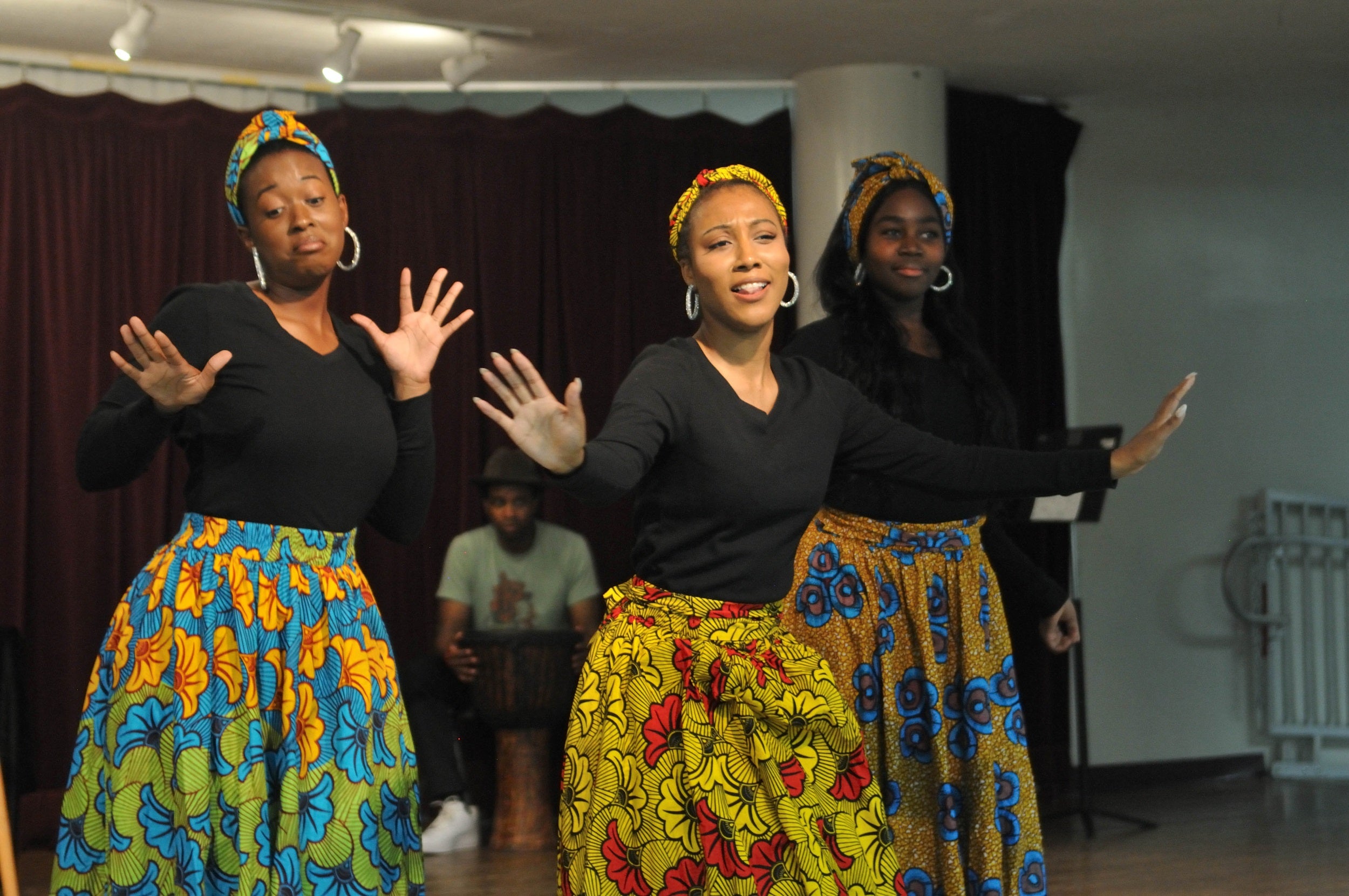 Three woman in colorful skirts performing on stage Three woman in colorful skirts performing on stage