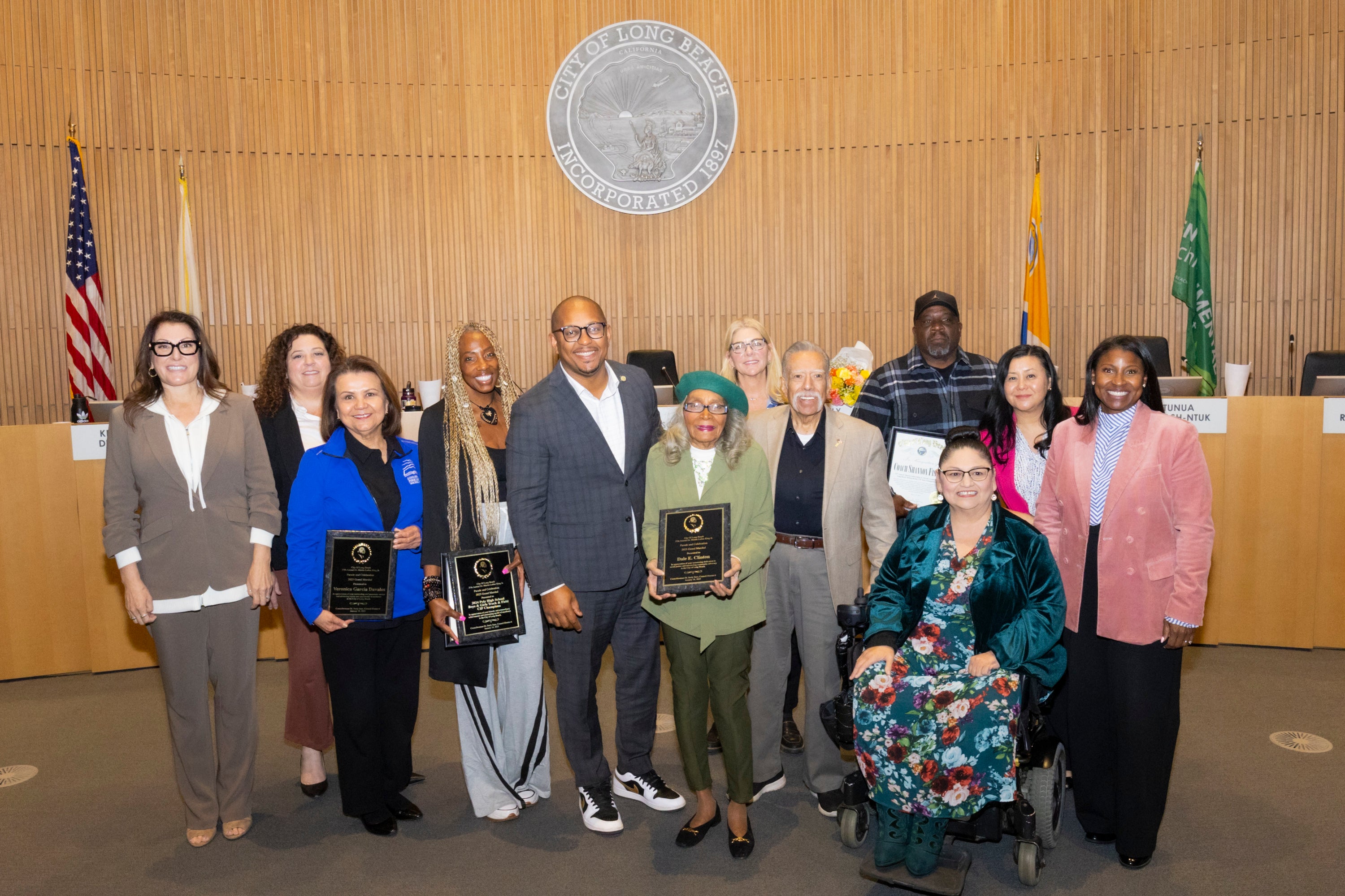 A group of people standing in City council chambers.
